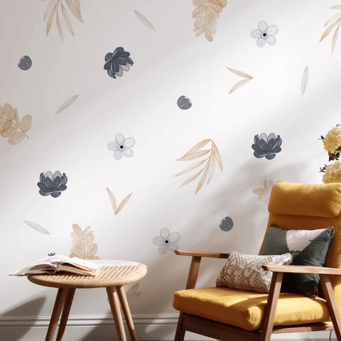 Yellow armchair with decorative pillows against a wall with floral wall stickers.