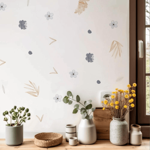 Decorative wall with floral decals, vases with plants on a wooden surface.
