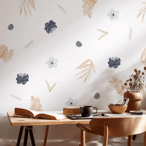Decorative wall with floral decals above a wooden desk with a book and mug.