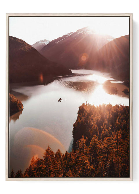 Mountain lake photography print with bright sun flare and golden hour light.