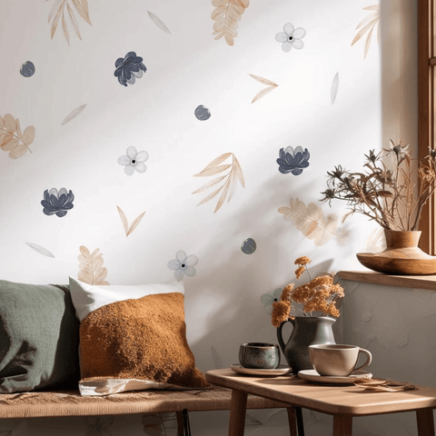 Cozy living room with floral wallpaper, pillows, and a small table with a cup and vase.