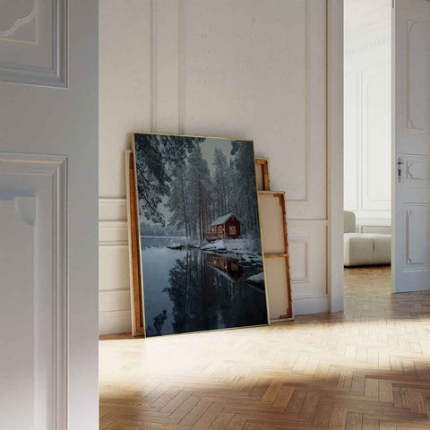 Rustic framed winter art of a snow covered cabin by a reflection lake