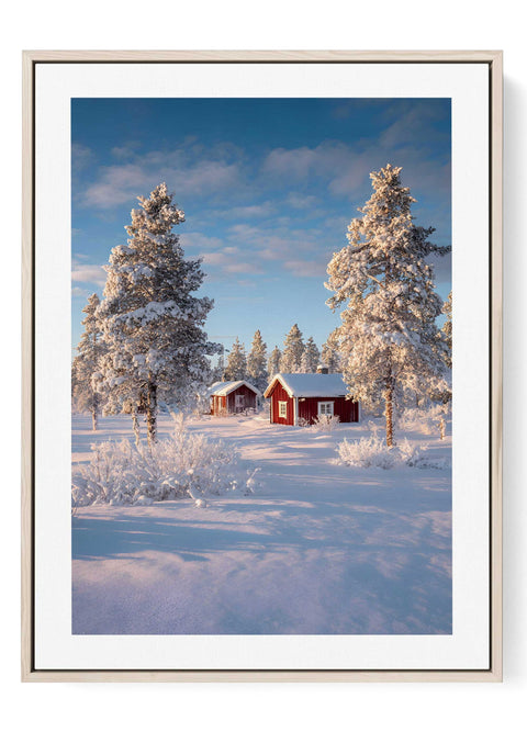 Scandinavian winter landscape wall art featuring red cottages in snow covered pine forest